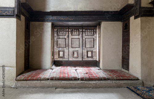 Interleaved wooden window (Mashrabiya) with built-in couch, and an embedded wooden cupboards at El Sehemy house, an old Ottoman era house in Cairo, originally built in 1648 photo