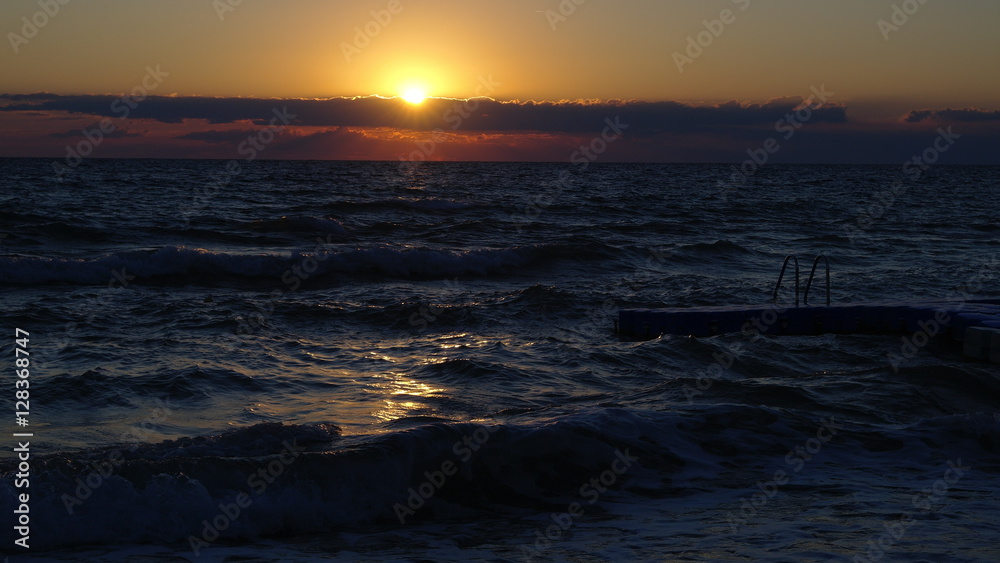 The sun rises over the waves