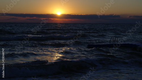 The sun rises over the waves © VladFlorin