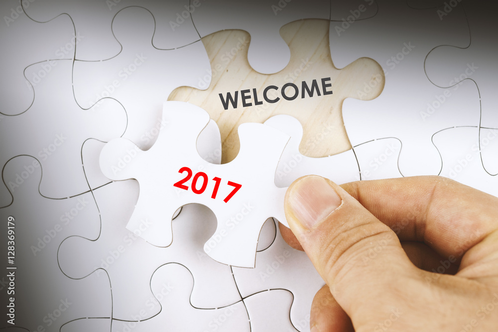 Hand holding a jigsaw puzzle with word WELCOME 2017. Hand holding a jigsaw puzzle with word WELCOME 2017.