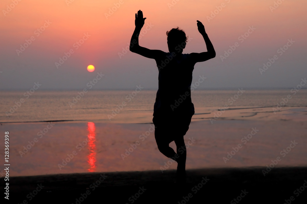 Fototapeta premium sunset and silhouette of a dancer in the beach
