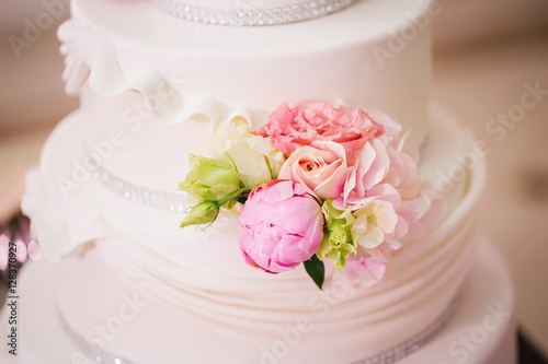 wedding cake decorated with roses and peonies