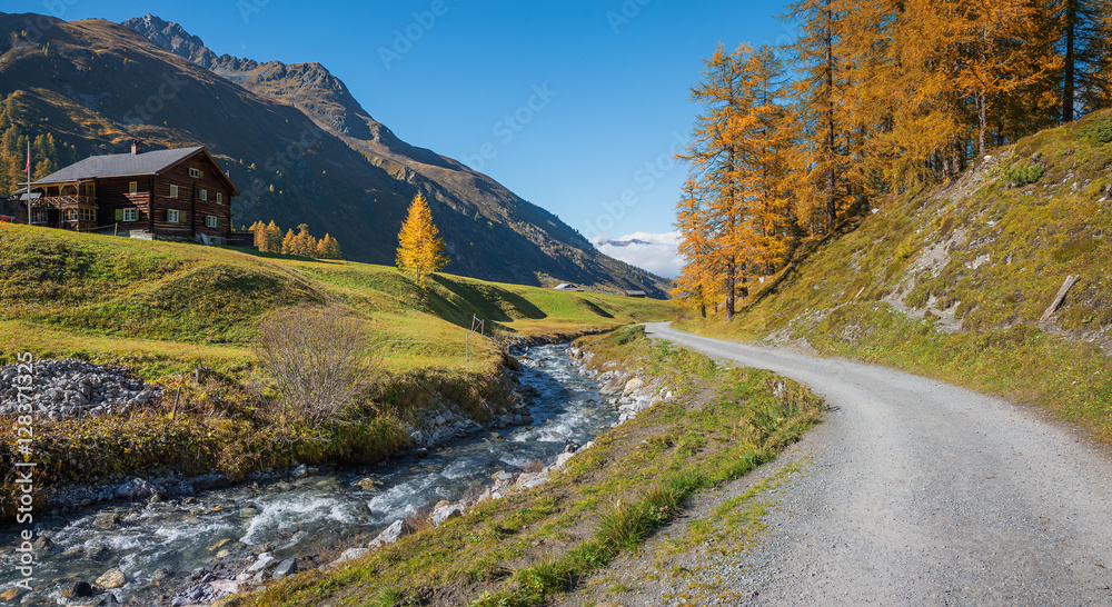 Wunderschöne Herbstlandschaft mit Lärchen, Hütte und Bergbach