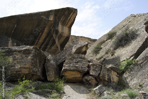 Landscape in Gobustan Rock Art Cultural Landscape Reserve in Azerbaijan, with rocks among grass. © Alizada Studios