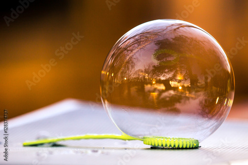 Soap bubble on wand lying on surface, showing round, angled, and straight shapes