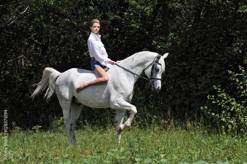 Beautiful girl in the park ride horse bareback