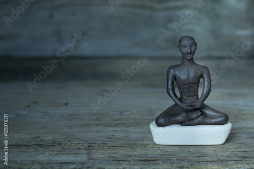 Silhouette young monk statue praying practicing yoga and meditate. Vipassana concept. Yoga  health life concept.