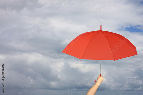 Red umbrella in hand and rain protection.