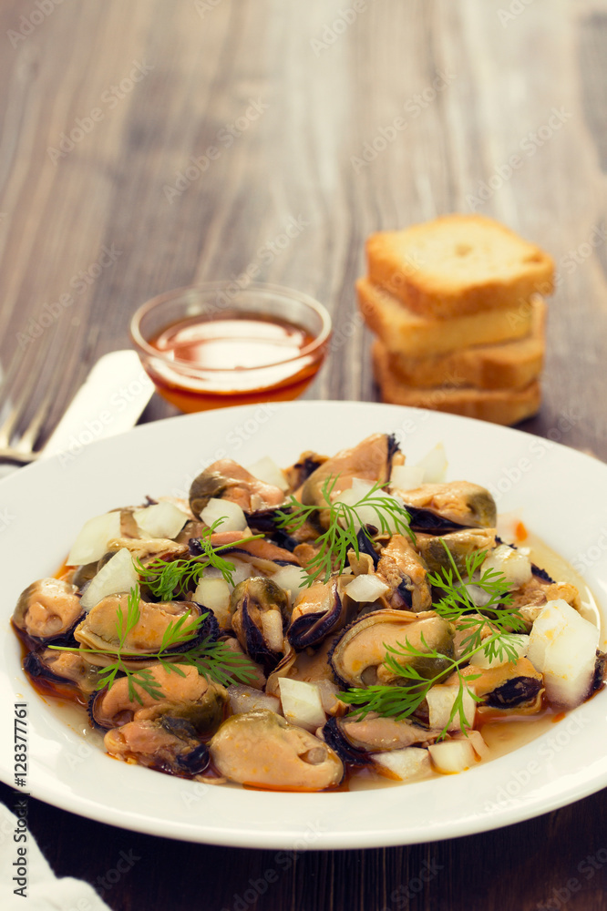 salad mussels with onion in sauce in white plate