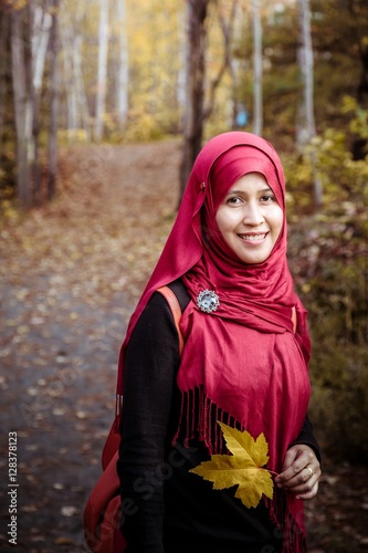 Muslim woman in North America during autumn with colorful maple leaf as background