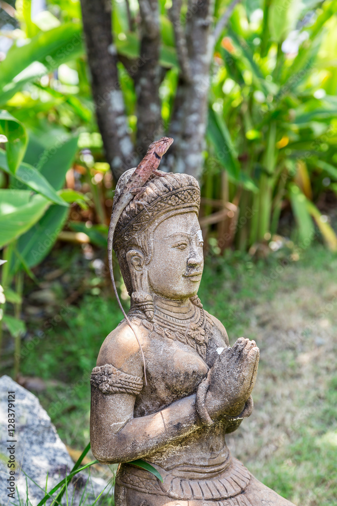 Eidechse auf dem Kopf  einer Frauenstatue. Garten Statue im Thailand.