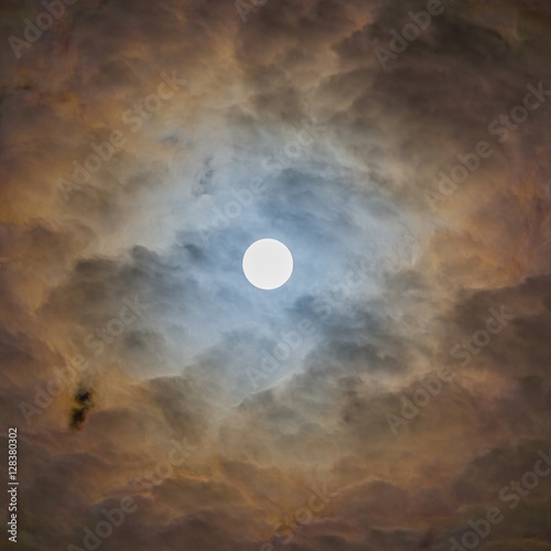 Moon surrounded by clouds with surreal lighting