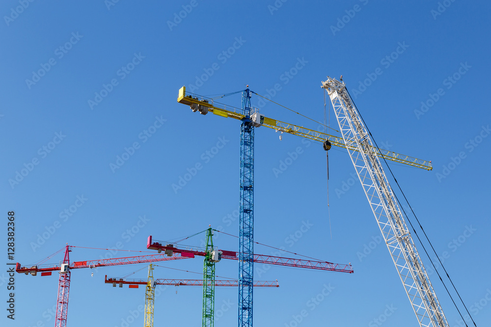 modern construction cranes in front of blue sky. modern construction cranes in front of blue sky.