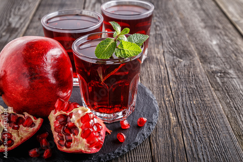 Glasses of pomegranate juice with fresh pomegranate fruits 