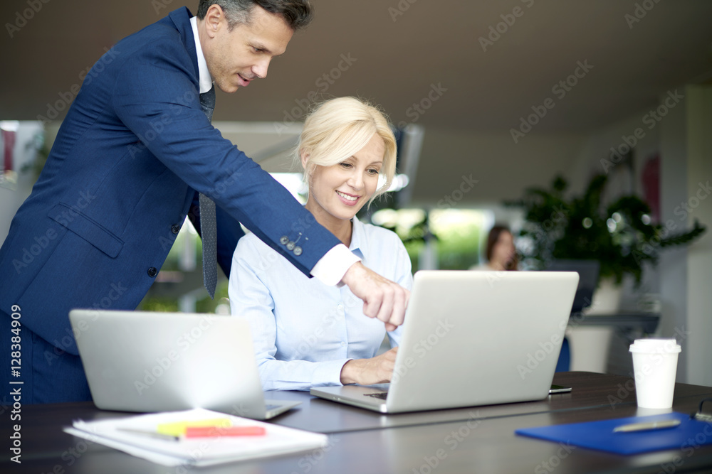 Teamwork in the office. Portrait of two happy colleagues using a laptops while working on business presentation. Teamwork in the office. Portrait of two happy colleagues using a laptops while working on business presentation.