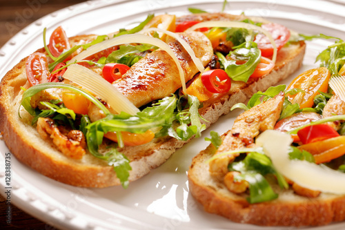 Chicken sandwich on fresh bread with arugula tomato and cheese