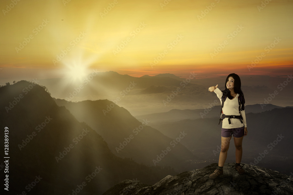 Woman traveler showing thumb in the sunset