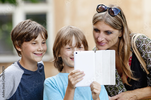 Bild auf Leinwand Two Boys Showing Something to Mother on Tablet