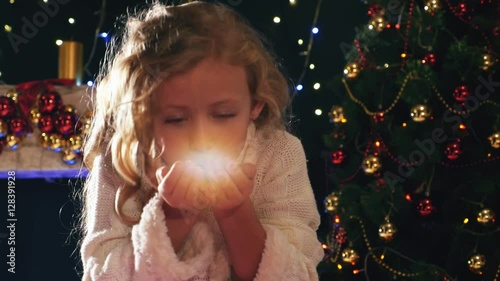 Cute girl fairy blowing magical glitter at christmas night.