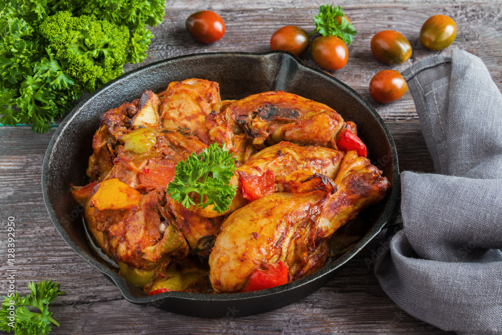 Chakhokhbili, chicken stew, cooked with tomatoes, bell peppers, spices and herbs. Dark wooden background. Chakhokhbili, chicken stew, cooked with tomatoes, bell peppers, spices and herbs. Dark wooden background.