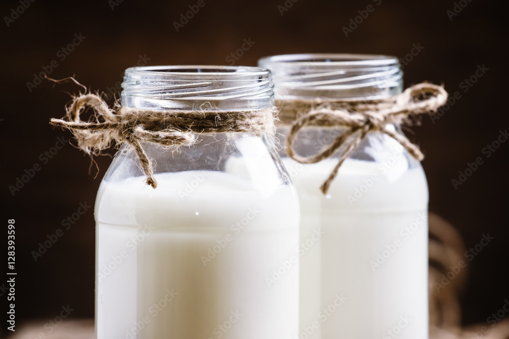 Fresh cow milk or cream in glass bottles, rustic style, vintage Fresh cow milk or cream in glass bottles, rustic style, vintage