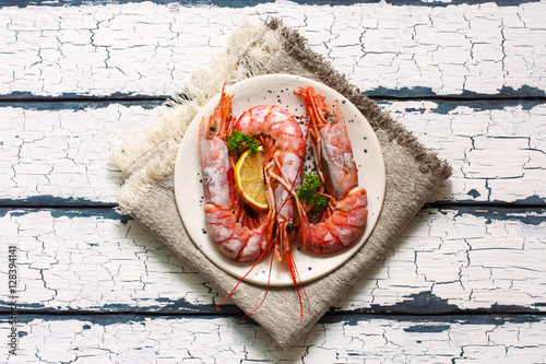 Large shrimps on white plate over wood white background photo