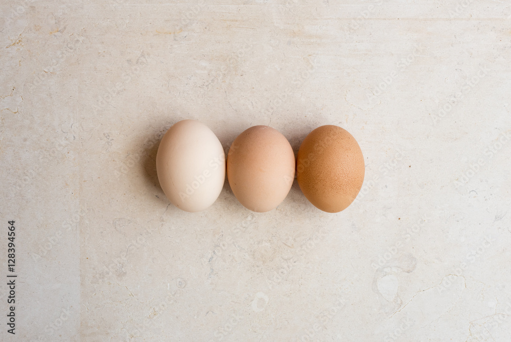 High angle view of three eggs on natural limestone background High angle view of three eggs on natural limestone background