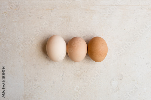 High angle view of three eggs on natural limestone background