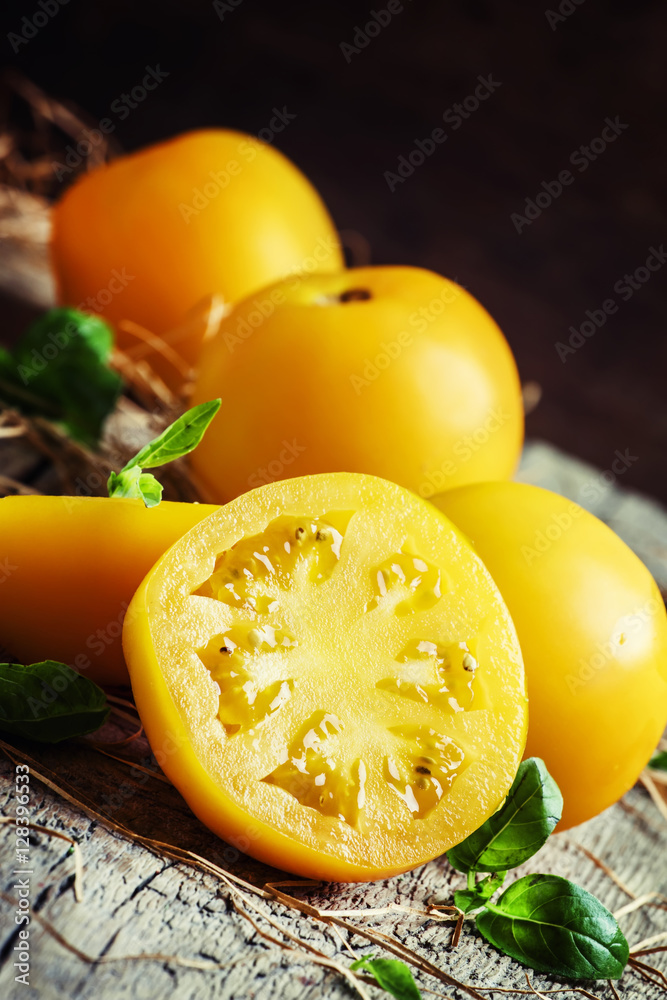 Cut large yellow tomatoes and green leaves of basil, vintage woo
