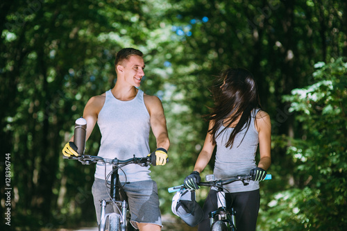 Young Couple Riding Bike In Park