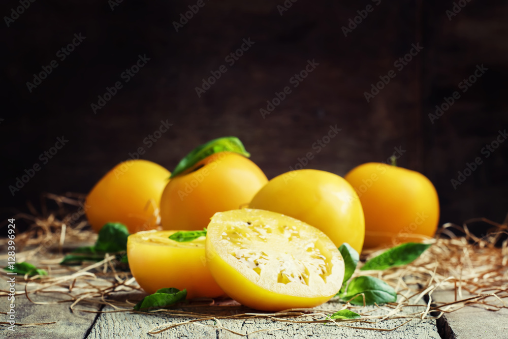 Cut large yellow tomatoes and green leaves of basil, vintage woo Cut large yellow tomatoes and green leaves of basil, vintage woo