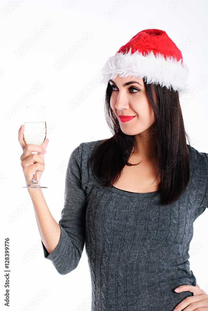 Young lovely woman in santa hat with glass of champagne on white background Young lovely woman in santa hat with glass of champagne on white background