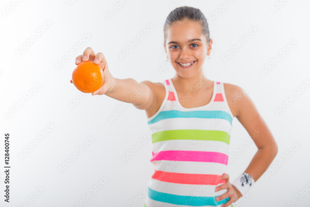 Teen girl for a healthy lifestyle, vitamins winter. active lifestyle schoolchildren. Girl in a bright striped shirt holding an orange in her hand, selective focus Teen girl for a healthy lifestyle, vitamins winter. active lifestyle schoolchildren. Girl in a bright striped shirt holding an orange in her hand, selective focus