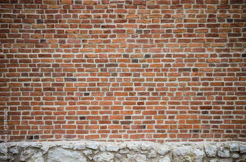 Vintage red brick wall with white limestone foundation