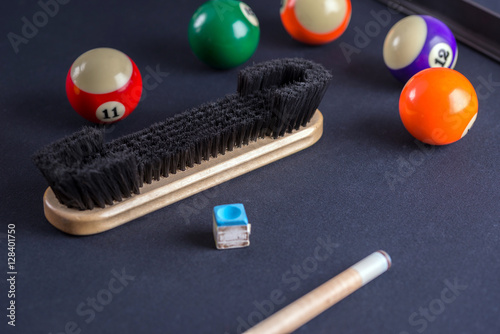 Brush for cleaning of billiard table with cue and balls.