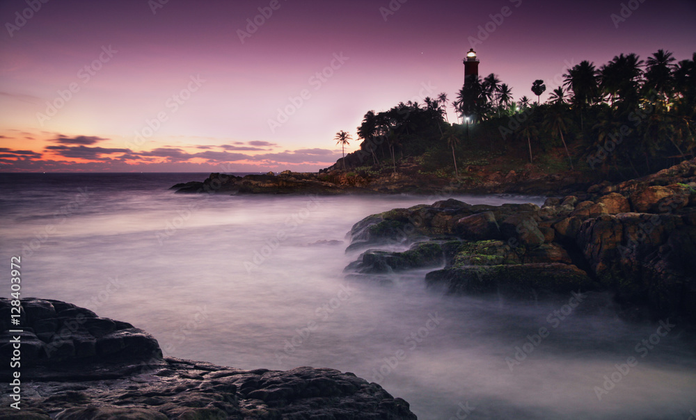 Colorful sunset at the Kovalam beach, Kerala, India. Lighthouse view. Long exposure.