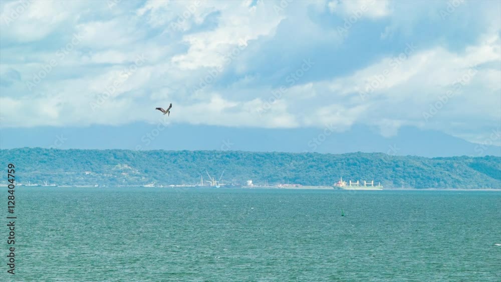 Wide Ocean Scene in Costa Rica with Industrial Sea Port with Pacific Ocean Foreground and Mountain Background Wide Ocean Scene in Costa Rica with Industrial Sea Port with Pacific Ocean Foreground and Mountain Background