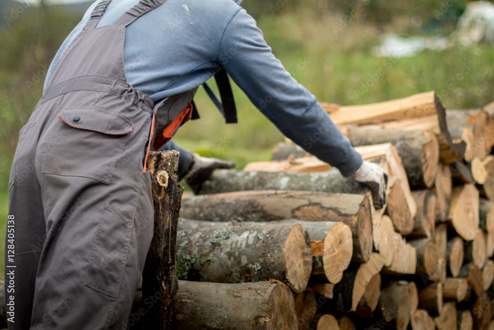 Close-up of lumberjack holding a wooden log. Provision of firewo Close-up of lumberjack holding a wooden log. Provision of firewo