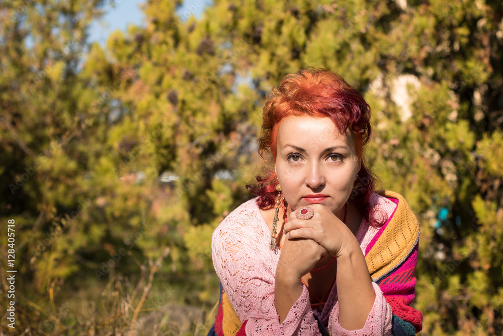 Portrait of hipster woman with pink curly hair. Beautiful hippie with red hair