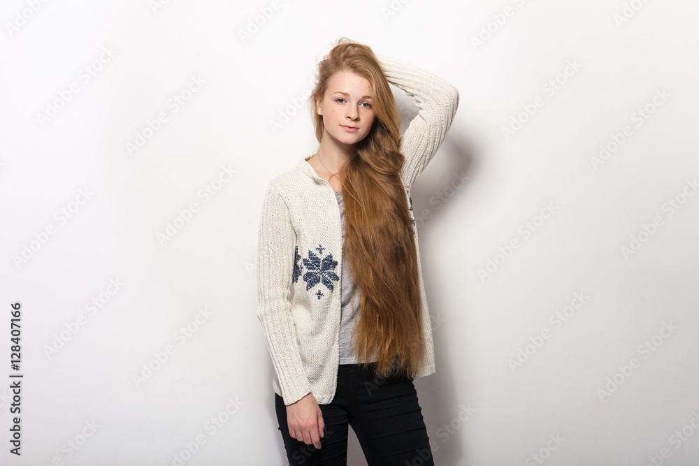 Human pose expressions and emotions. Portrait of young adorable redhead woman showing her gorgeous extra long natural red hair in cozy sweatshirt Human pose expressions and emotions. Portrait of young adorable redhead woman showing her gorgeous extra long natural red hair in cozy sweatshirt