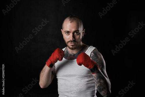 Handsome man with strong power body. Fighter ready for fight. Bald man in white shirt. Concept of martial arts. Calm look af brave person. © Anatoliy Karlyuk