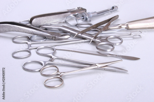 surgical instruments and tools including scalpels  forceps tweezers arranged on a table for surgery