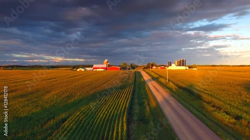The American Heartland At Sunset. A country road, corn fields, farms and a dramatic sky conspire to make a uniquely beautiful  Midwest landscape.