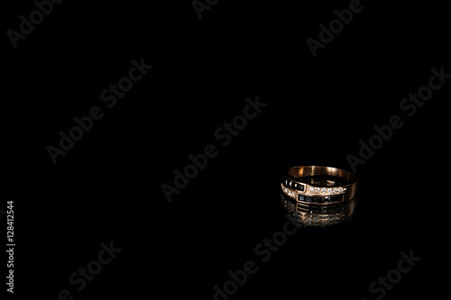 Golden ring with diamonds on studio on black background