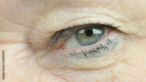Woman aged 60s opens and closes up one eye. Close up photo