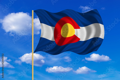 Flag of Colorado waving on blue sky background photo