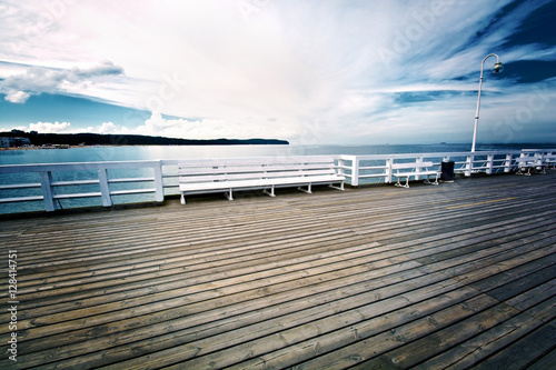 White bench on wooden pier in Sopot, Poland.