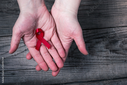 Картината върху платно Red ribbon on palms - awareness and support for people living with HIV