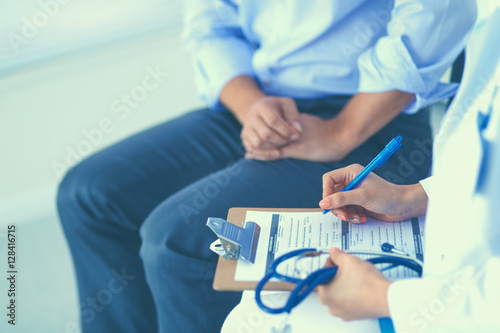 Doctor woman sitting with male patient at the desk
