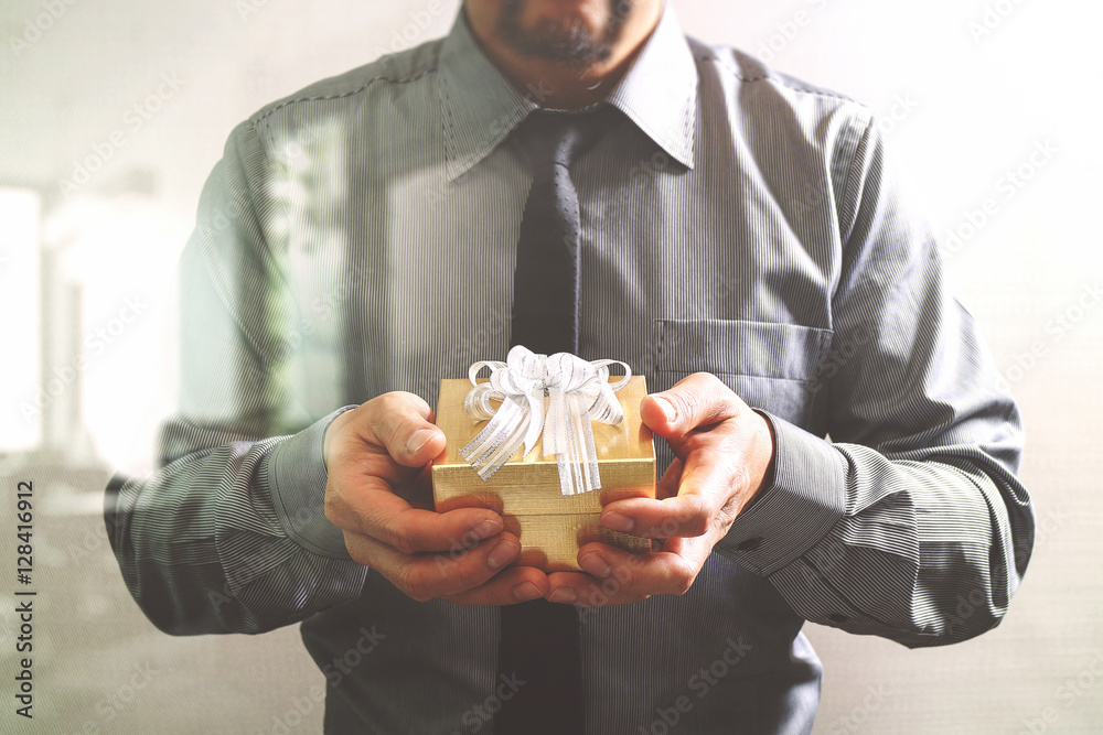gift giving,businessman hand holding a gift box in a gesture of gift giving,businessman hand holding a gift box in a gesture of